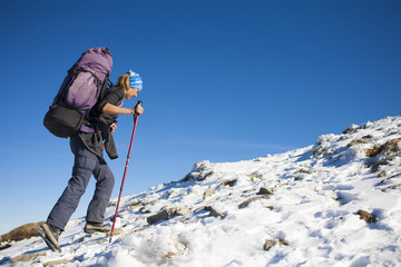 The girl with the backpack is on the slope.