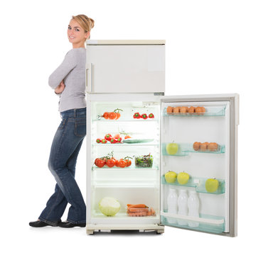 Woman With Arms Crossed Leaning On Open Refrigerator