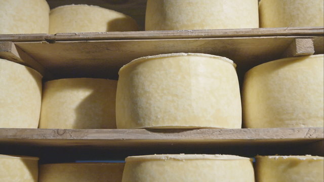 Cheeses stored on wooden shelves - dolly motion