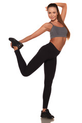 Fitness woman in sport style standing against isolated white background