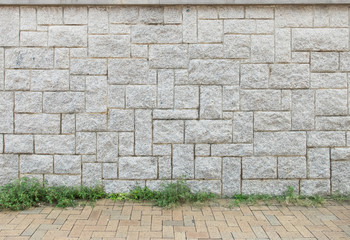 Light Gray Stone Wall Background Texture with Brown Stone Ground and Grass