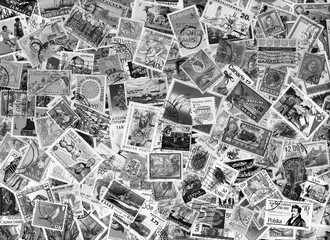 Black & white image of a large world foreign postage stamp collection background