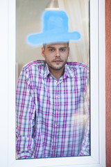 Man at window with blue drawn hat. Funny picture