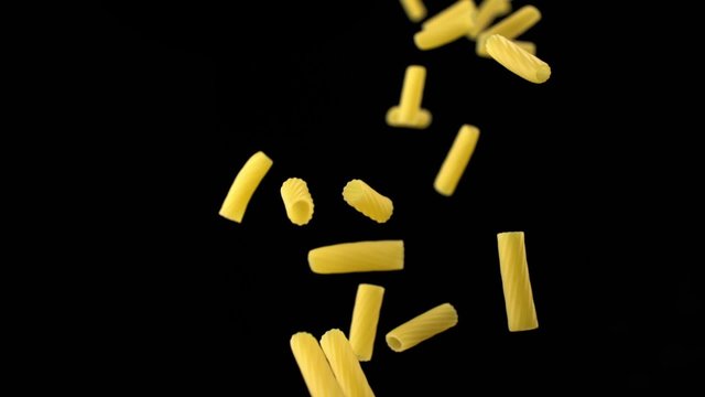 Throwing tortiglioni pasta on black background shooting with high speed camera, phantom flex.