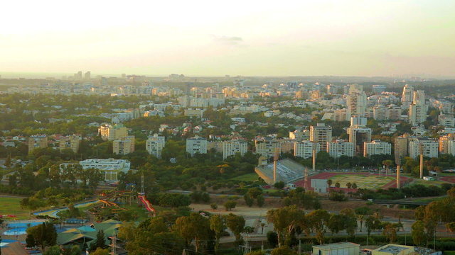 Aerial view of cityscape of Tel aviv at sunset. Places like Residential neighborhood in northern Tel Aviv, Hayarkon Park, National Sports center of Tel Aviv, Meymadion water park.
