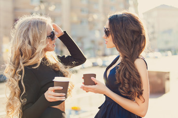 Lifestyle portrait of two best friends girls spending time in the center of the city at nice summer day, trendy fashion looks