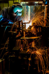 worker with protective mask welding metal
