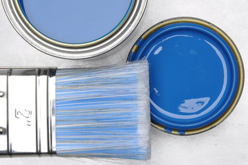 Top view of blue paint can with brush on grey metal background