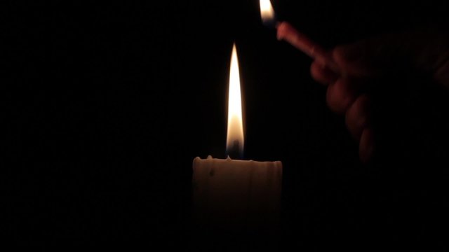 candle being lit in the dark