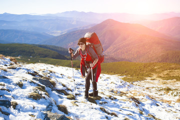 The girl with the backpack goes to the mountain top.