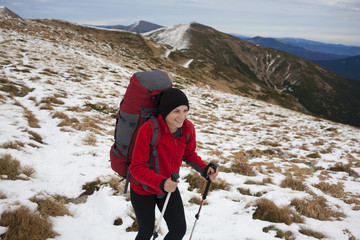 Girl with backpack is traveling in the mountains.
