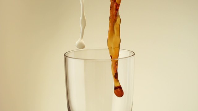 Pouring coffee and milk into glass shooting with high speed camera, phantom flex
