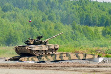 T-80 tank drives on bridge induced through obstacle