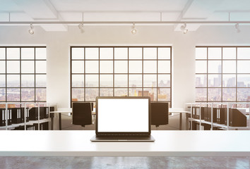 A workplace in a bright modern office. A working desk is equipped with a modern laptop with white copy space in the screen. Docs shelves. New York view in the windows. Toned image. 3D rendering.