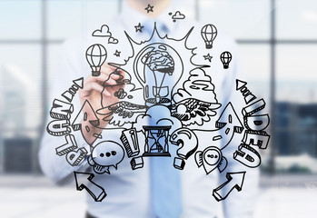 A businessman is drawing a business plan development sketch on the glass screen. A modern panoramic...