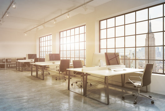 Workplaces in a sunset loft open space office. Tables are equipped with computers; book shelves. New York panoramic view. A concept of a high quality consulting services. Toned image. 3D rendering.