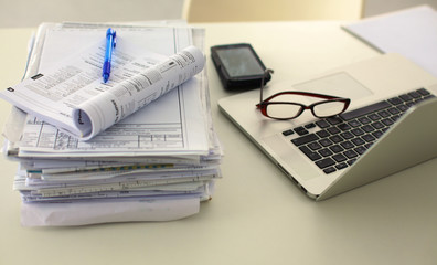 Office table with blank notepad and laptop 