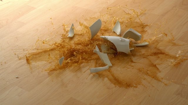 Drpping cup of coffee and breaking on wooden floor shooting with high speed camera, phantom flex.