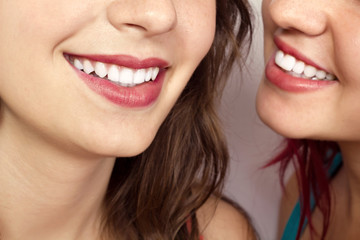Two women whispering and smiling