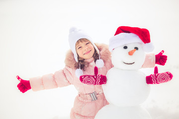 Child and snowman in winter