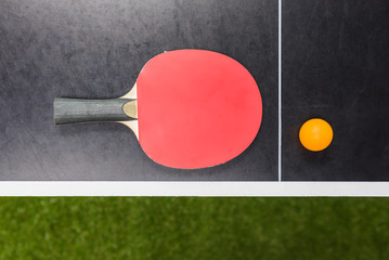table tennis racket with ball on black table