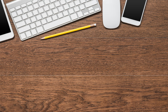 office wooden table with yellow pencil, tablet, keyboard, mouse