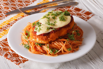 Chicken Parmigiana and pasta with tomatoes close-up 

