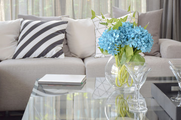 Light blue flower and wine glasses on center table with striped