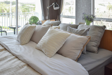 stylish bedroom interior design with white striped pillows on be