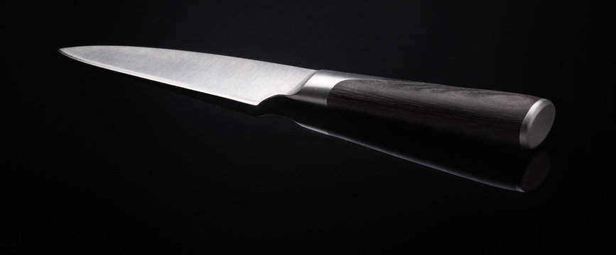 Image of kitchen knife on black background with reflection