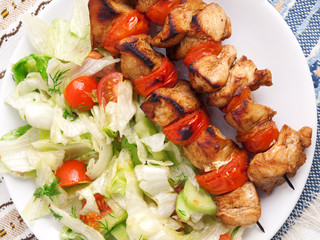 Pork skewers with salad