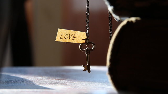 Key and text "Love". Golden key to LOVE idea.
