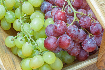Grappes de raisin blanc et rose en vrac dans un panier