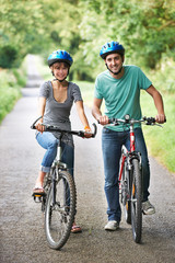Obraz premium Young Couple Cycling On Country Road