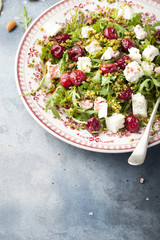 Salad with arugula, cherries and goat cheese.