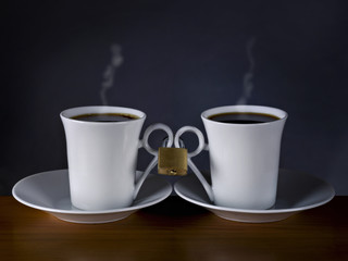 Two cups of coffee, together with a lock on black background