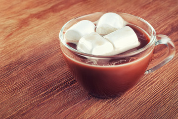 cup of hot chocolate with marshmallows on wooden background