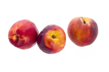 Fototapeta na wymiar three peaches displayed on white background