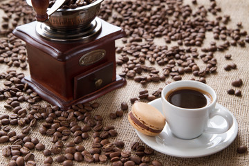 cup of coffee with macarons on a background coffee beans