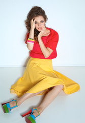 Young woman sitting on the floor, isolated in white background