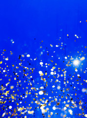 Christmas blue background. Golden holiday glowing abstract glitt