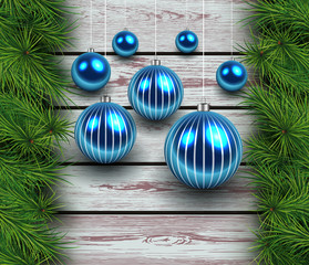 Christmas wooden background with fir branches and balls.