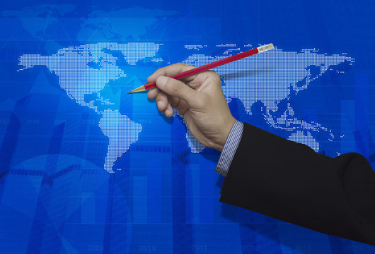Businessman Hand Holding A Pencil Over Blue Digital World Map Ba