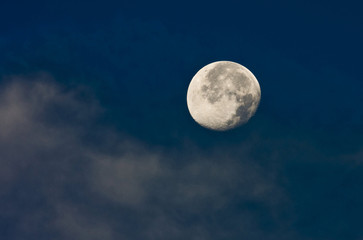 View of the moon in early morning blue sky.