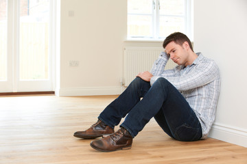 Depressed Man Sitting In Empty Room Of Repossessed House - obrazy, fototapety, plakaty
