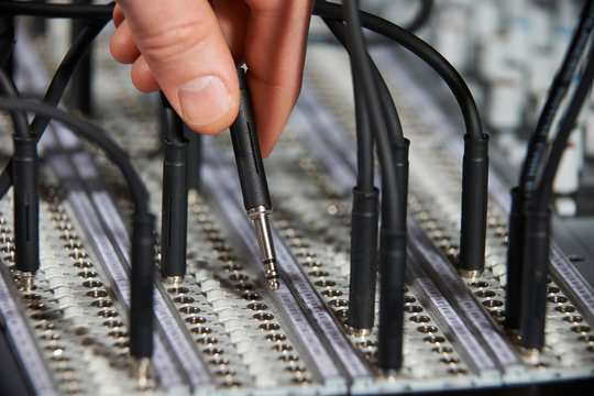 Hand Plugging Cable Into Recording Studio Patch Panel
