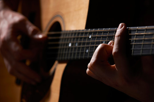 Close Up Of Guitarist Playing Acoustic Guitar