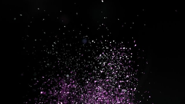 Camera follows colorful confetti flying after being exploded against black background. Shot with high speed camera, phantom flex 4K.  Slow Motion. Unedited version is included at the end of clip.