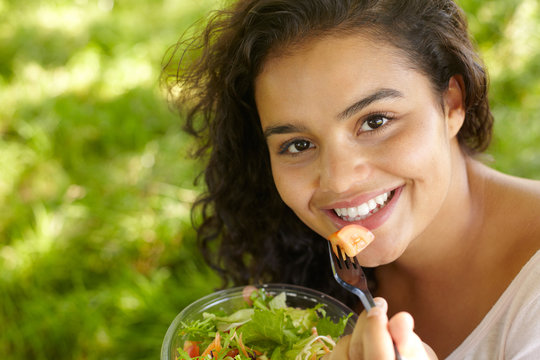 Young Woman Eating Healthy Salad Outdoors
