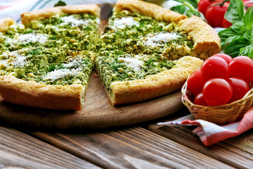 Slices of open pie with spinach and tomato cherry on table close up